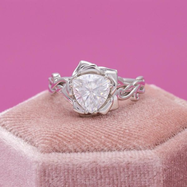 This intricate flower setting still lets the moissanite's sparkle shine brightly.