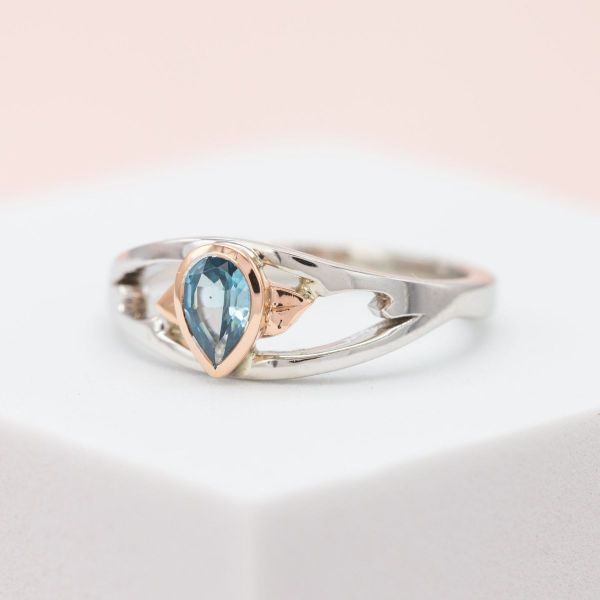 A split-shank band is used to create movement and space in this blue zircon rose and white gold engagement ring.