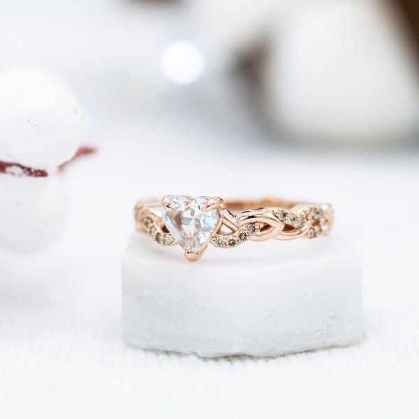Celtic and Bavarian designs sprawl across the rose gold bands of this knot-inspired bridal set, and the aquamarine and champagne diamonds add a pop of color.