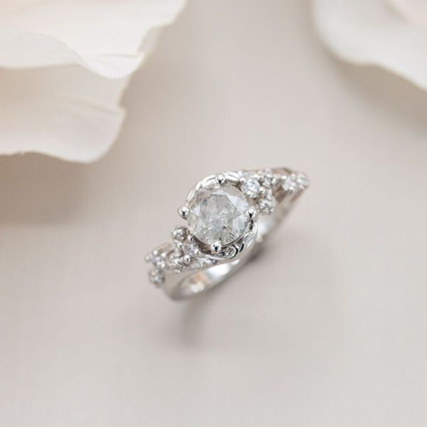 A light salt and pepper diamond sits in white gold for a nature inspired engagement ring.