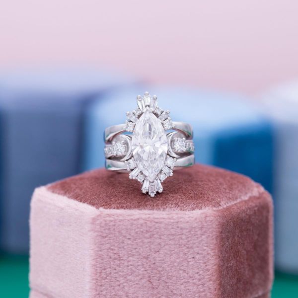 A lab created, marquise cut lab diamond takes center stage in a halo of accent diamonds and white gold.