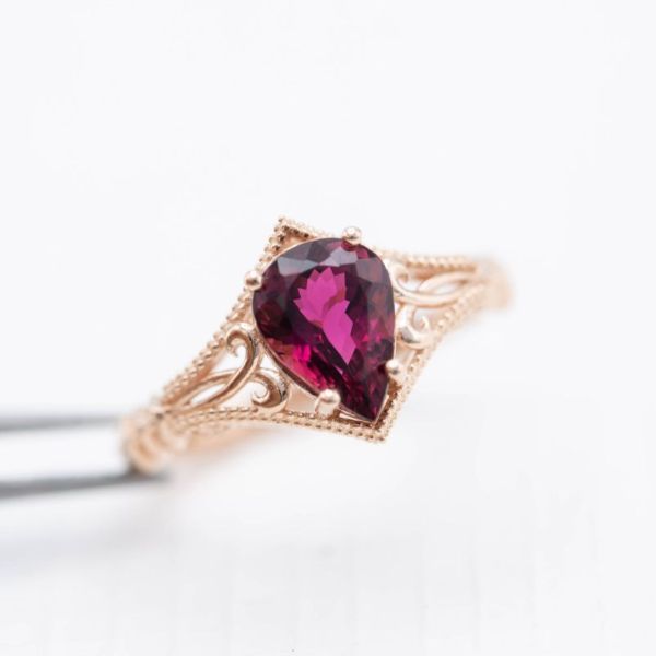 复古风格的粉色碧玺订婚戒指，精致的玫瑰金镶嵌。