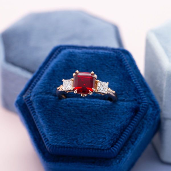 Enclosed in luxe rose gold double-prongs, a lab ruby smolders next to two princess cut diamonds on a petite band.