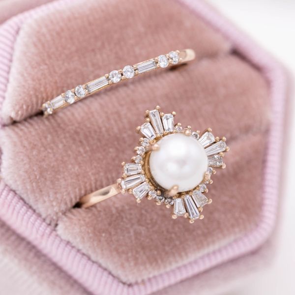 A gorgeous ballerina halo contrasts the pearl's curves with the striking geometry of baguette diamonds.