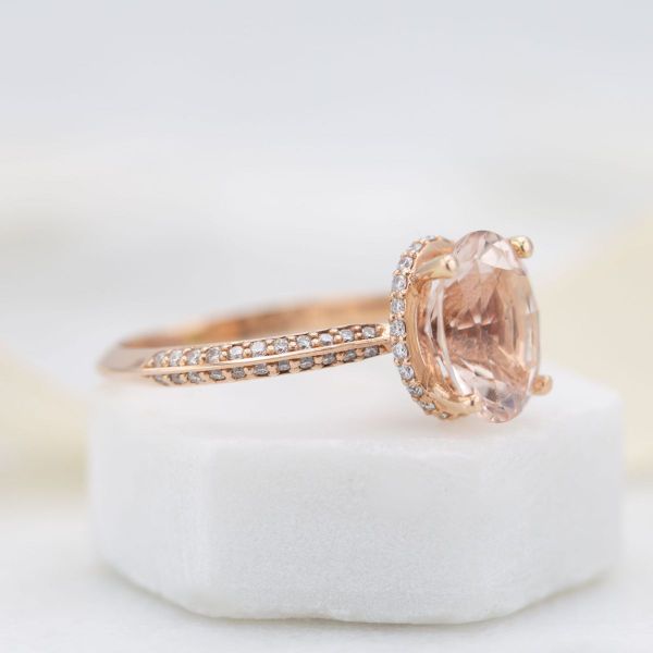 This morganite engagement ring is dripping in diamond accents, set in a double pavé rose gold band with a hidden halo.
