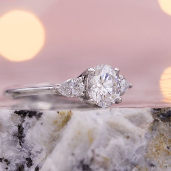 This 3-stone ring uses a simple, very slightly tapered band to offset the simple elegance of the tapered diamond center setting.