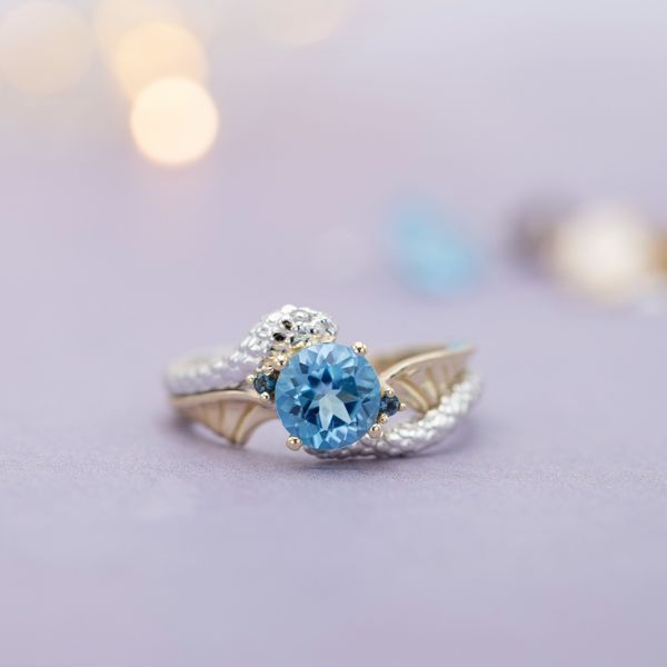The white gold snake wraps its way around this Swiss blue topaz engagement ring.