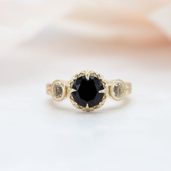 A deep black onyx sits in the center of this yellow gold engagement ring.