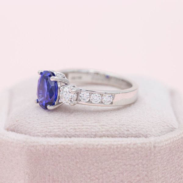Channel-set diamond accents add sparkle to this sapphire and diamond three stone ring.