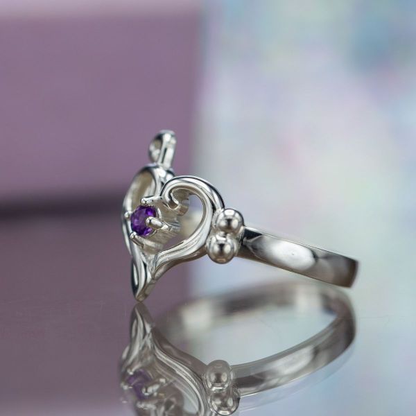 A purple amethyst adds a pop of color to this musical engagement ring.