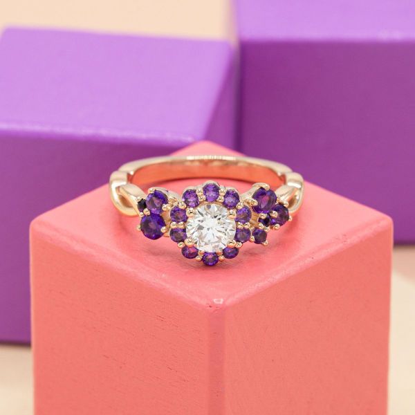 Amethysts act as accents in a floral design of this diamond engagement ring.