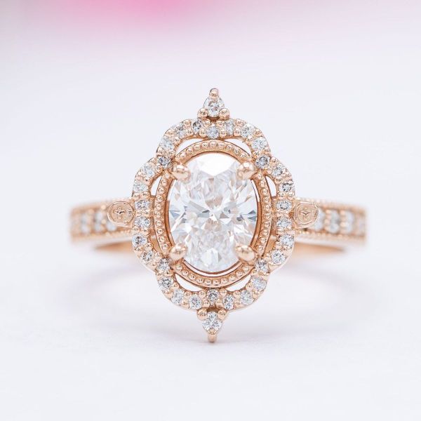 An antique diamond halo surrounds the diamond center stone of this engagement ring.