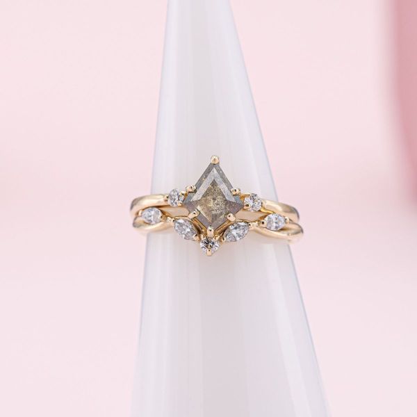 A kite shaped salt and pepper diamond is held by button prongs in yellow gold.