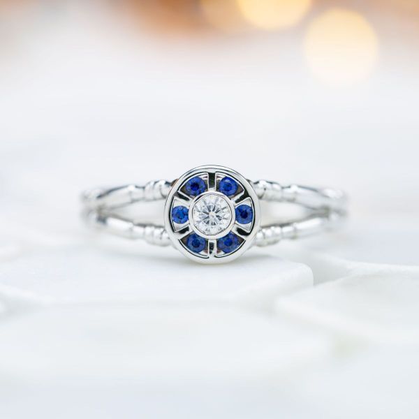 A round cut moissanite and six surrounding sapphires resemble R2D2 in this Star Wars inspired ring.