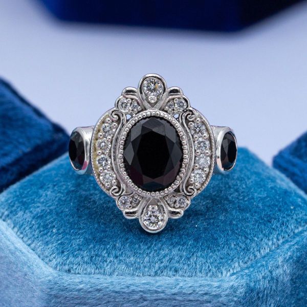 Flowing curves and diamond accents create an extravagant halo around a black onyx center stone in this Edwardian inspired ring.