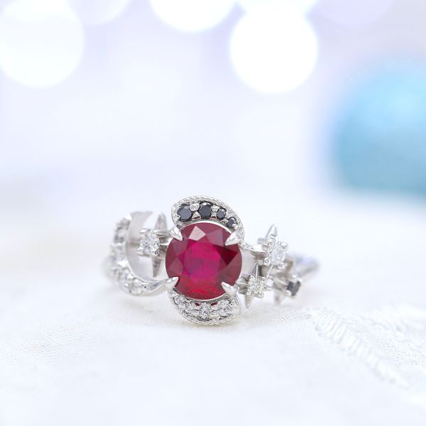 一枚大胆独特的红宝石订婚戒指，上面有新月、星星和以阴阳为灵感的黑白钻石。