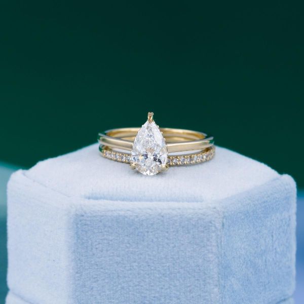 A lab created, pear cut diamond is center stage of this solitaire engagement ring.