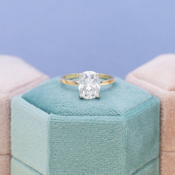 A cushion cut moissanite solitaire engagement ring.
