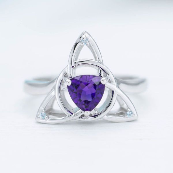 This engagement ring features a bewitching trillion cut amethyst inside a white gold trinity knot.