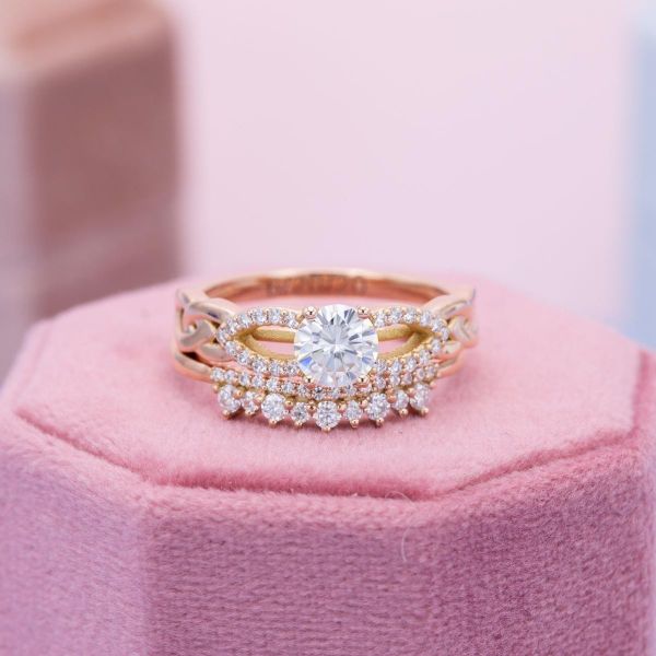 A brilliant round moissanite takes center stage in this yellow gold bridal set.