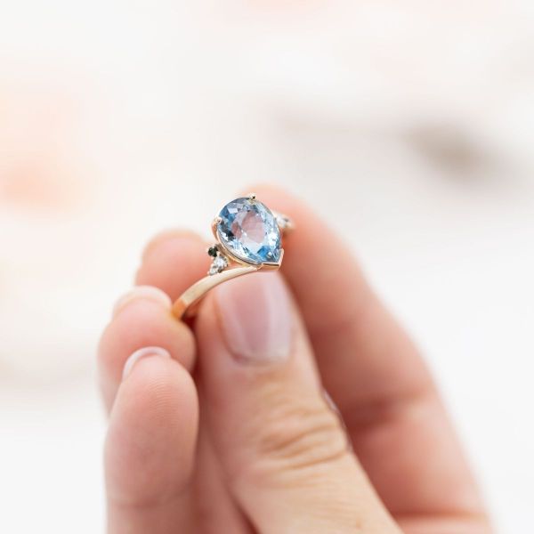 The aquamarine in this engagement ring is highlighted by subtle touches like its unique prongs and colored side stones.