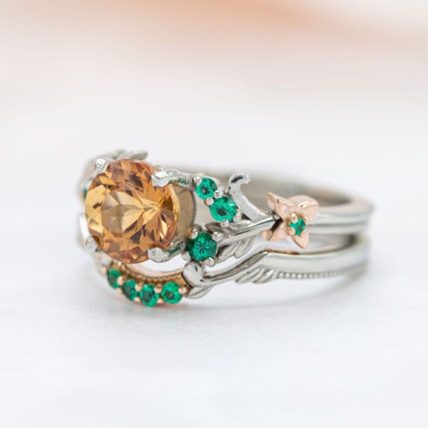 Rose gold flowers and leaves adorn the white gold band of this autumn-inspired ring that features imperial topaz and emerald accent stones.