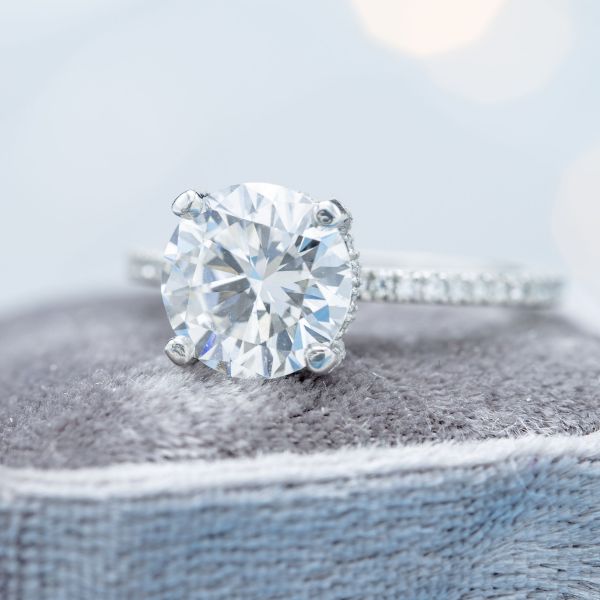 干净的线条和最小的装饰在这款当代铂金订婚戒指。美丽的钻石线条在精致的柄上，让2ct钻石中心的石头流行起来。