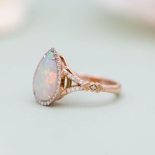 This opal engagement ring has diamond accents throughout its halo and split-shank band.