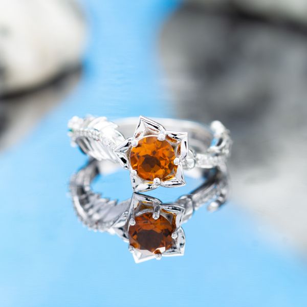 This delicate flower engagement ring winds white gold around the finger and adds a pop of rich orange citrine.