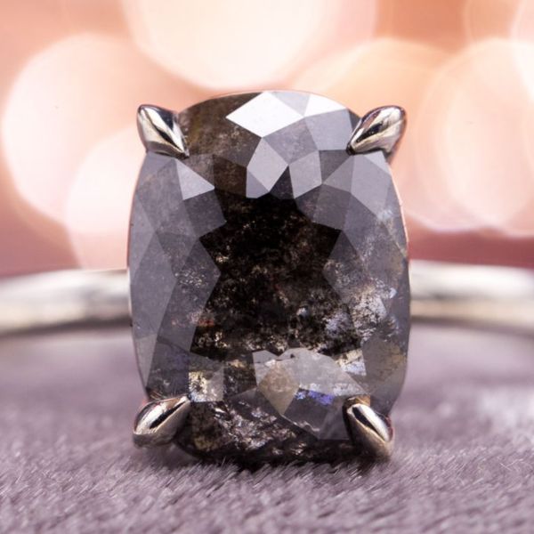 A modified, elongated rose cut allows this large black diamond to sit low to the finger. The black diamond is natural, getting its color from dense clouds of minerals trapped in the diamond.