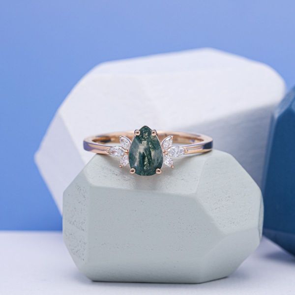 A pear cut moss agate with with marquise cut diamonds flanking the side.
