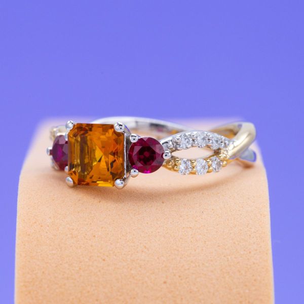 An Asscher cut citrine is set with ruby and diamond accents on a yellow and white gold twisted band.
