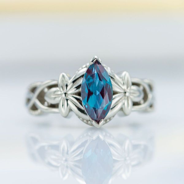 White gold flowers hold a lab created alexandrite in this custom engagement ring.