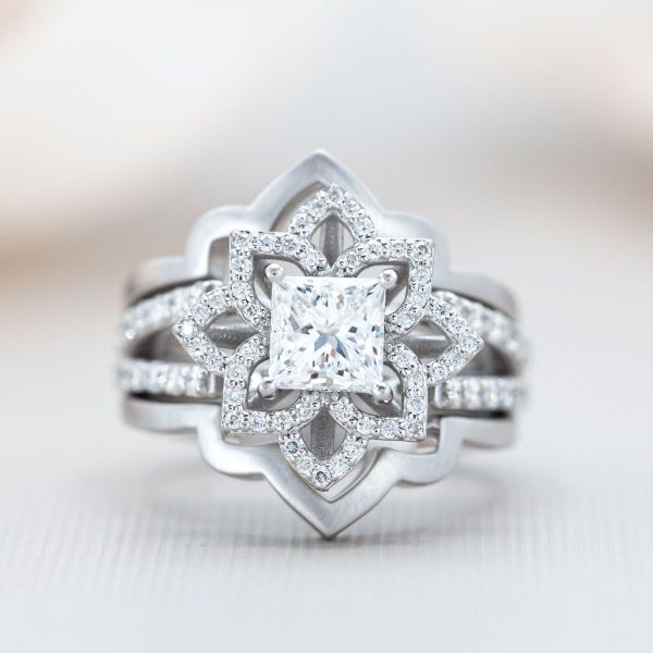 A princess cut diamond sits in the center of this mandala shaped bridal set.