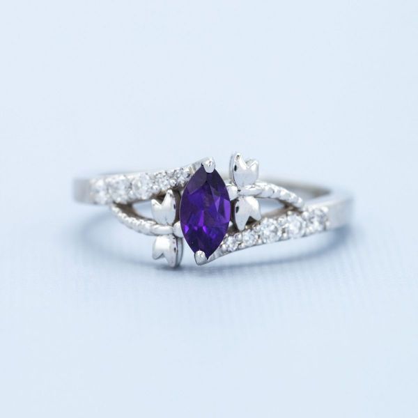 A marquise purple amethyst is the center stone of this dragonfly inspired white gold engagement ring.