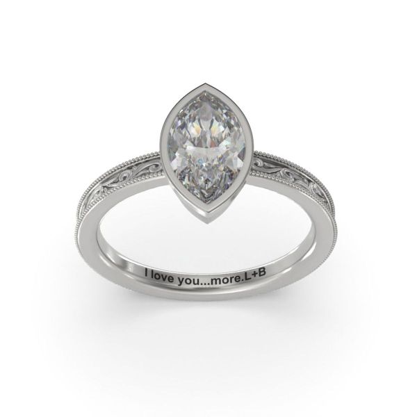 A marquise cut diamond is paired with an intricately engraved band in this engagement ring.