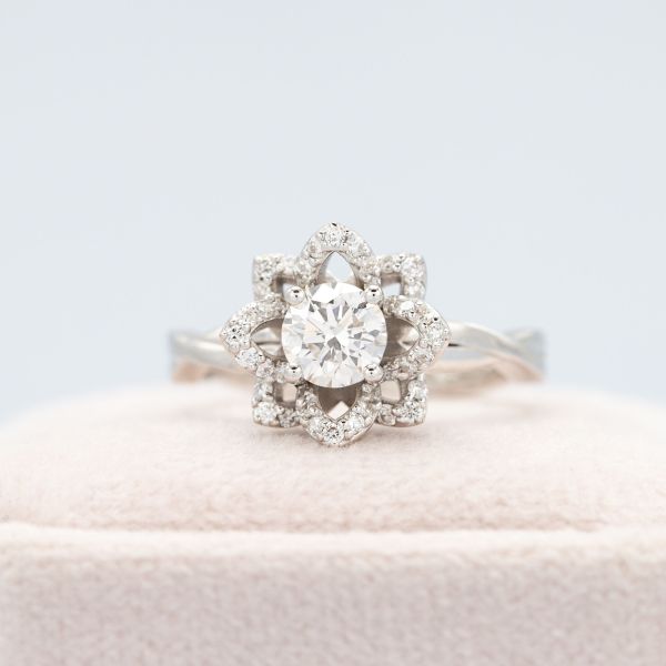Orchid-inspired petals sparkle with diamond accents in this floral engagement ring design.
