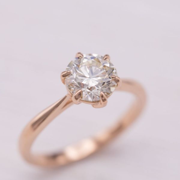 1.38ct圆形钻石，6个爪尖，中心石头下花瓣状的爪尖上镶有隐藏式钻石。