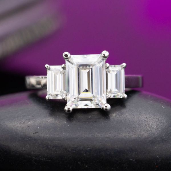Embracing the hall of mirrors effect of the emerald cut, this ring design keeps everything perfectly in line with the facets, and creates step symmetry between the band and the stones, to echo the step cuts of the gems.