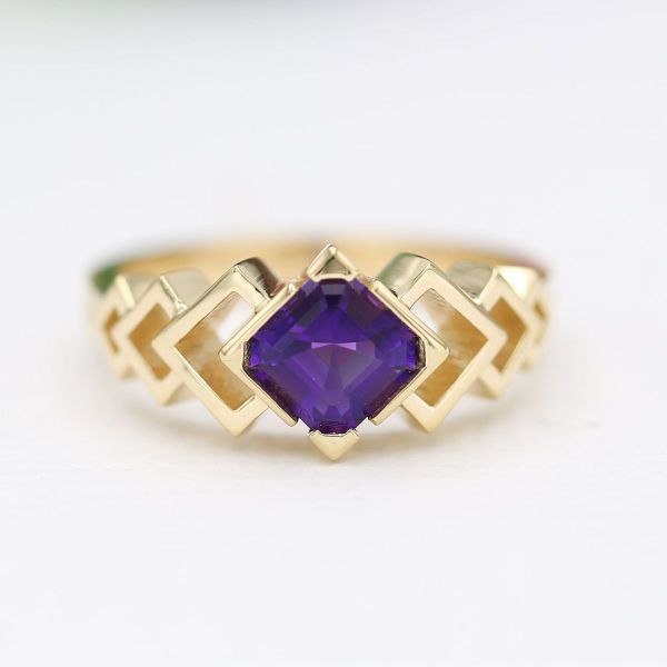 The yellow gold band of this engagement ring mirrors the maze-like effect of the Asscher cut amethyst center stone.