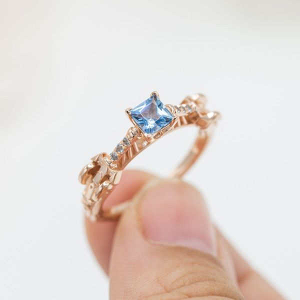The princess cut of the aquamarine in this ring brings out the blue color of the stone. 