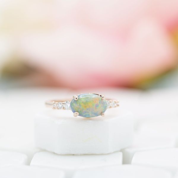 An east-west-set opal and diamond accents create a stunning engagement ring.
