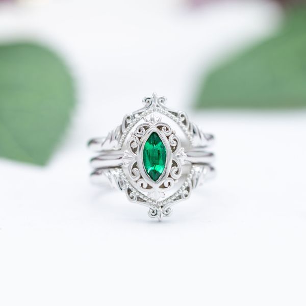 This stately engagement ring of white gold features a marquise cut emerald in the center.