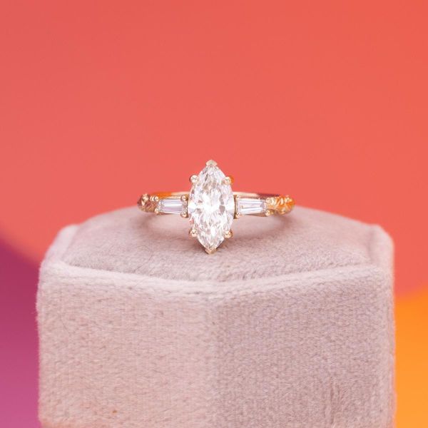 A marquise cut lab diamond is front and center in this yellow gold engagement ring.