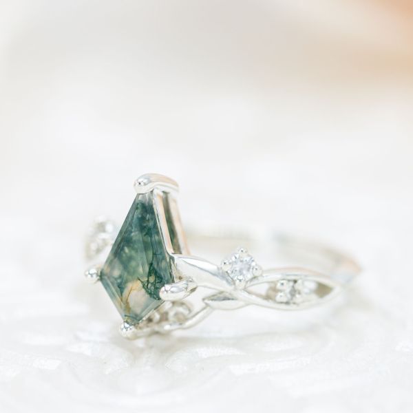 Kite shaped moss agate set in a vine and leaf white gold engagement ring.
