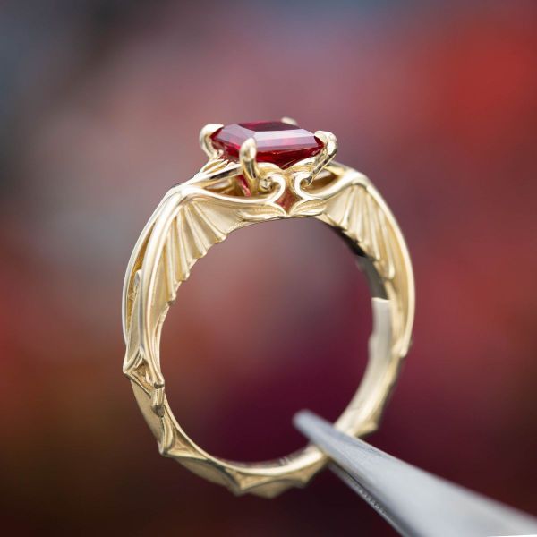 With a blood red ruby center stone, this engagement ring features a dragon-winged band and references to two fantasy fandoms.