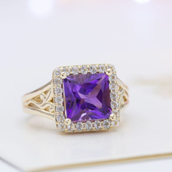 A square halo echoes the geometry of the princess cut amethyst center stone.