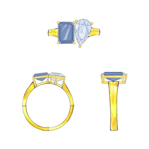 A sapphire sits beside a diamond on a yellow gold band.