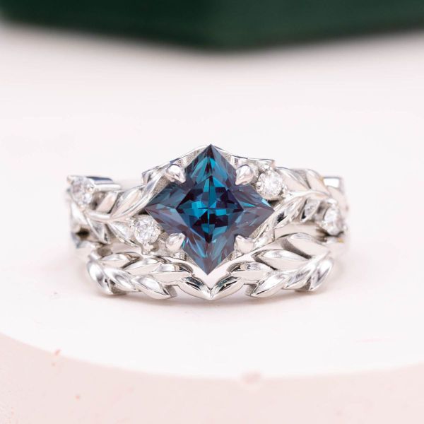 Platinum holds a lab alexandrite in the center of this engagement ring.