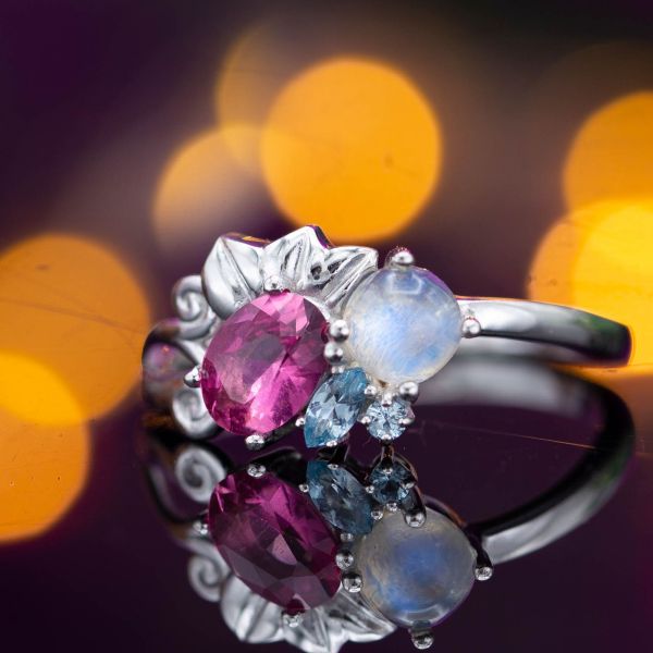 这款浪漫的星团戒指将月光石与粉色电气石和海蓝宝石搭配在一起，创造出引人注目和美丽的配色。